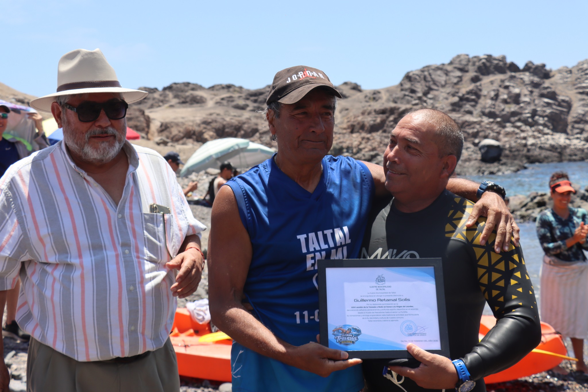 Tarzán Álvarez entrega diploma a Guillermo Retamal Solís por participación en travesía honor Virgen de Lourdes Taltal 2026.