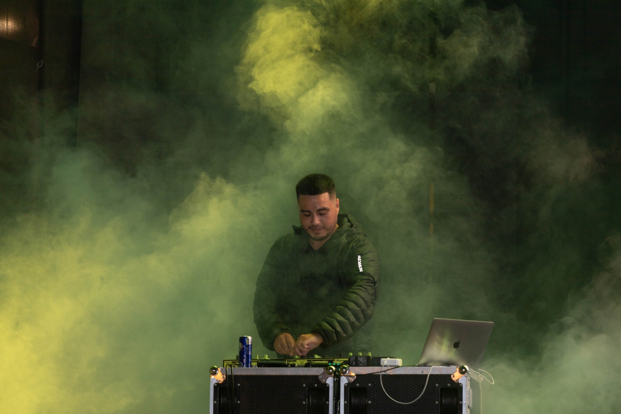 CrisMusic DJ concentrado mezclando música en consola con humo verde Gran Noche Juvenil Taltal 2026