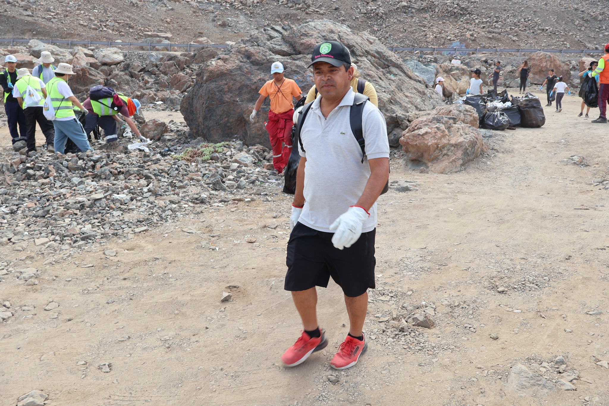 Participante de la jornada de limpieza camina por el sector costero de Los Vientos, Taltal, mientras equipos comunitarios retiran basura para resguardar patrimonio Chango (febrero 2026).