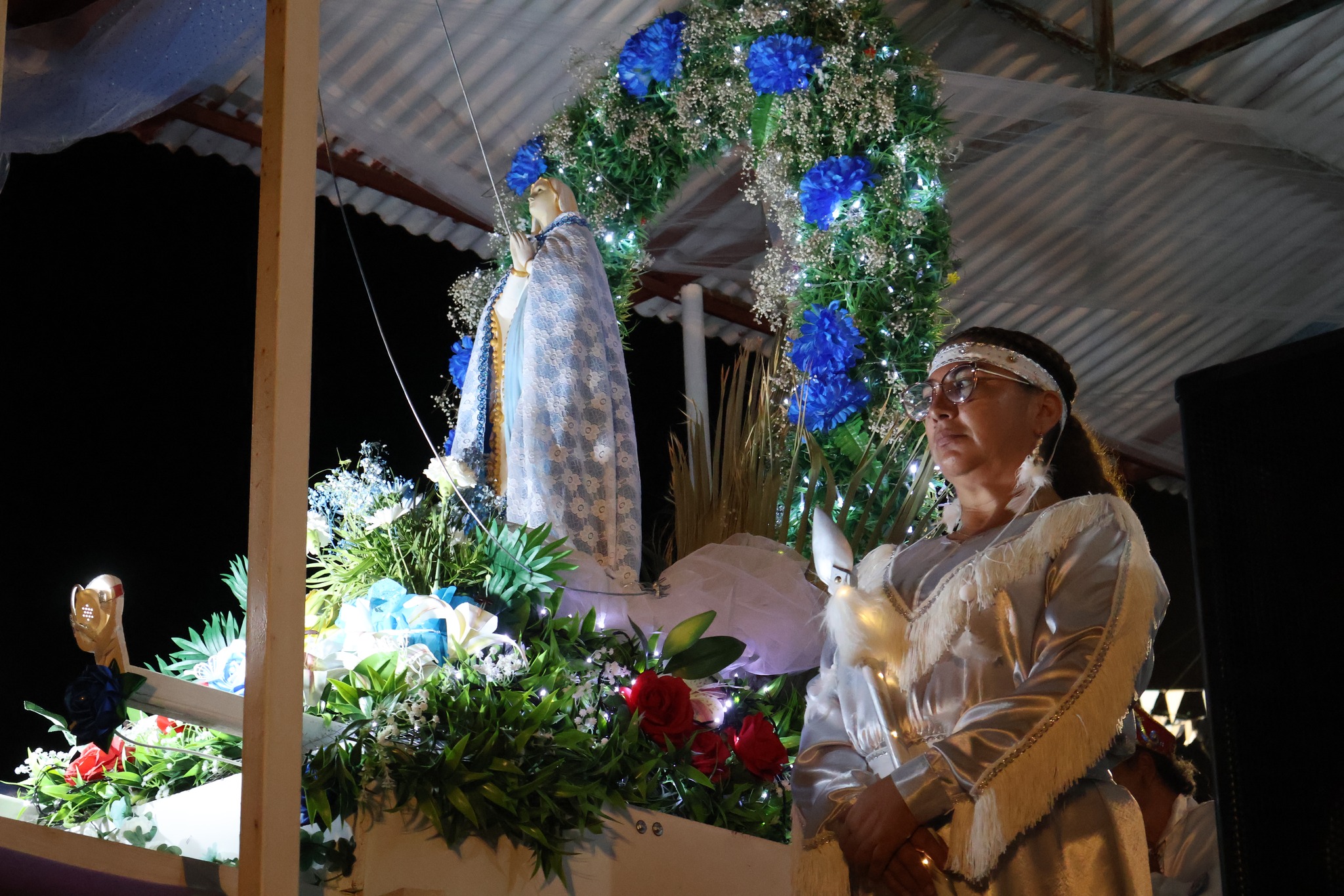 Bailarina en traje blanco con plumas orando frente a gruta Virgen de Lourdes sector La Puntilla Taltal 2026