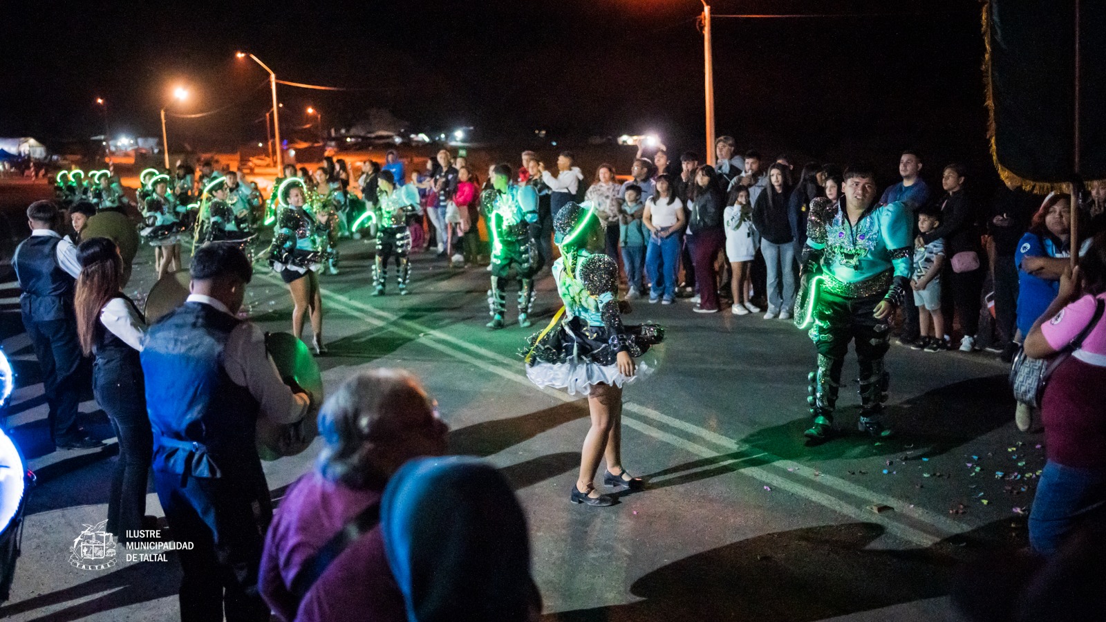 Niña en traje verde brillante con luces danzando en procesión nocturna Virgen de Lourdes La Puntilla Taltal 2026