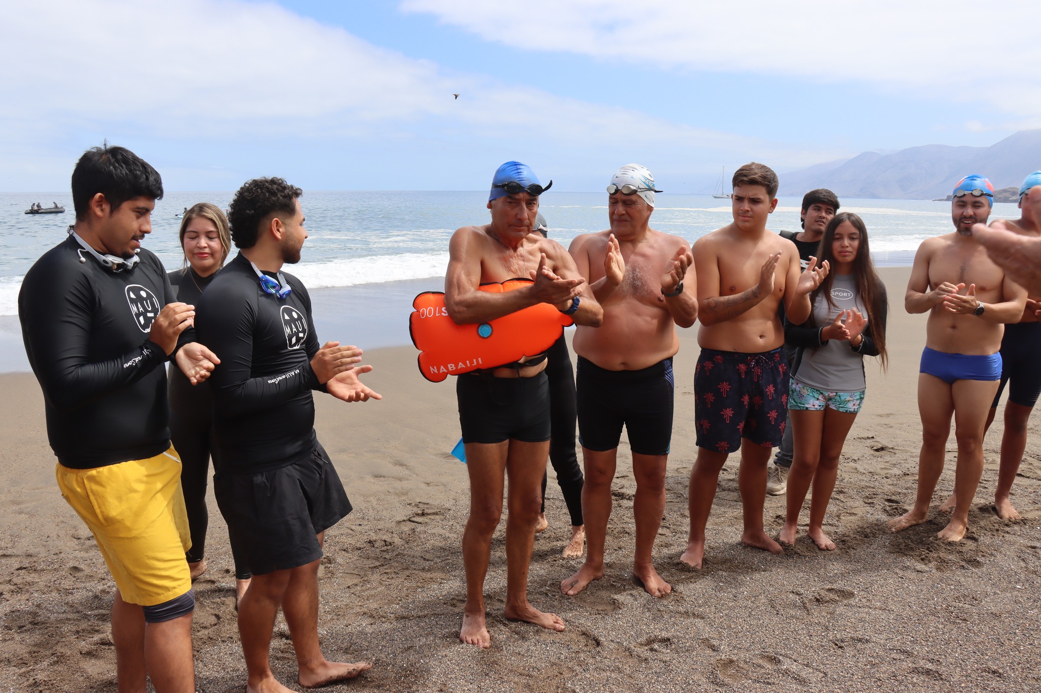 Tarzán Álvarez en primer plano con grupo de nadadores en preparación para 26° travesía Virgen de Lourdes Taltal febrero 2026.