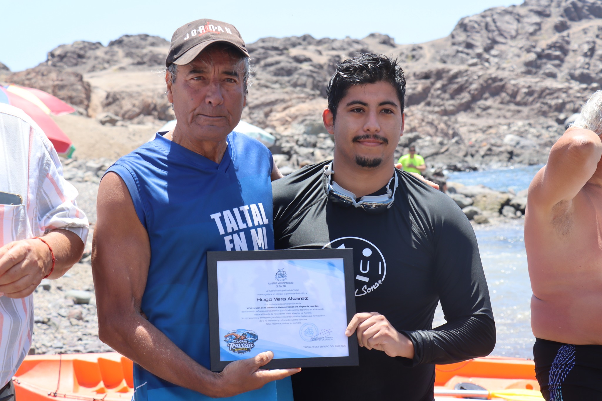 Tarzán Álvarez y Hugo Vera Álvarez celebran con diploma tras 26° travesía a nado Virgen de Lourdes sector La Puntilla Taltal febrero 2026.