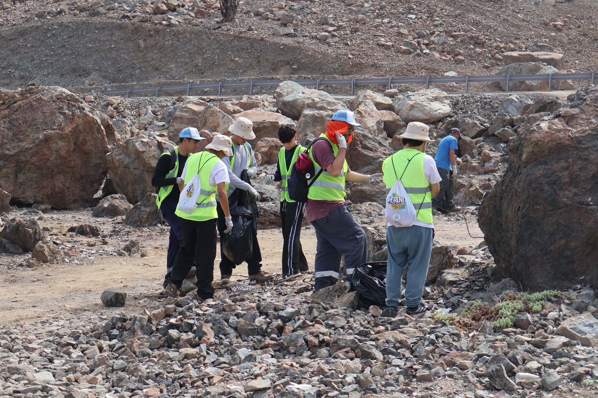 Trabajo en equipo para recolectar residuos en zona rocosa del litoral de Taltal durante operativo ambiental.