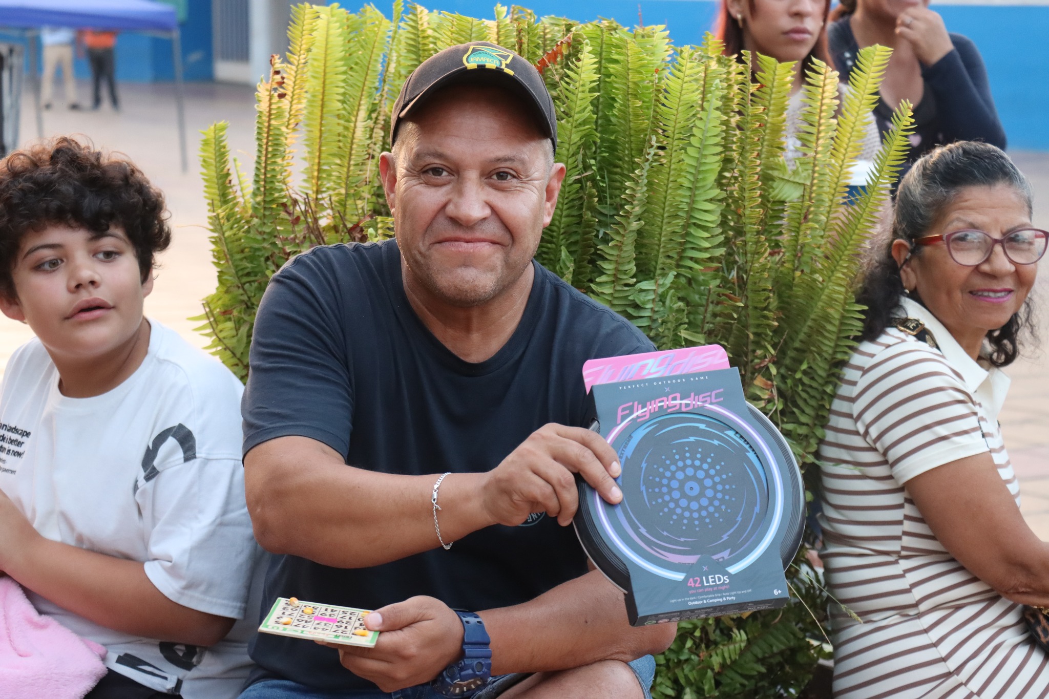 Ganador posa con un premio tipo parlante/karaoke durante el Gran Bingo Veraniego en Plaza Prat, Taltal.