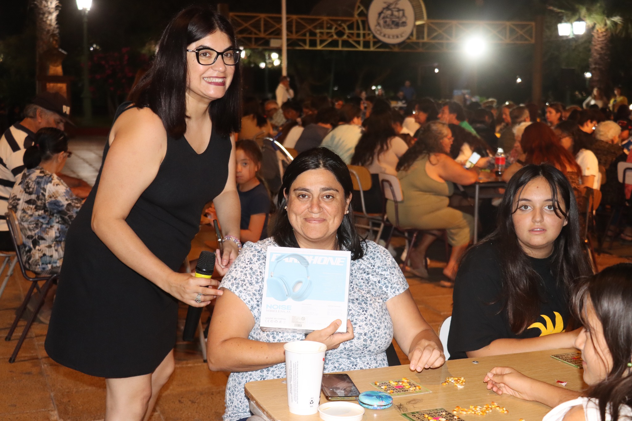 Participante recibe reconocimiento y premio durante el Gran Bingo Veraniego en Plaza de Armas, Taltal.