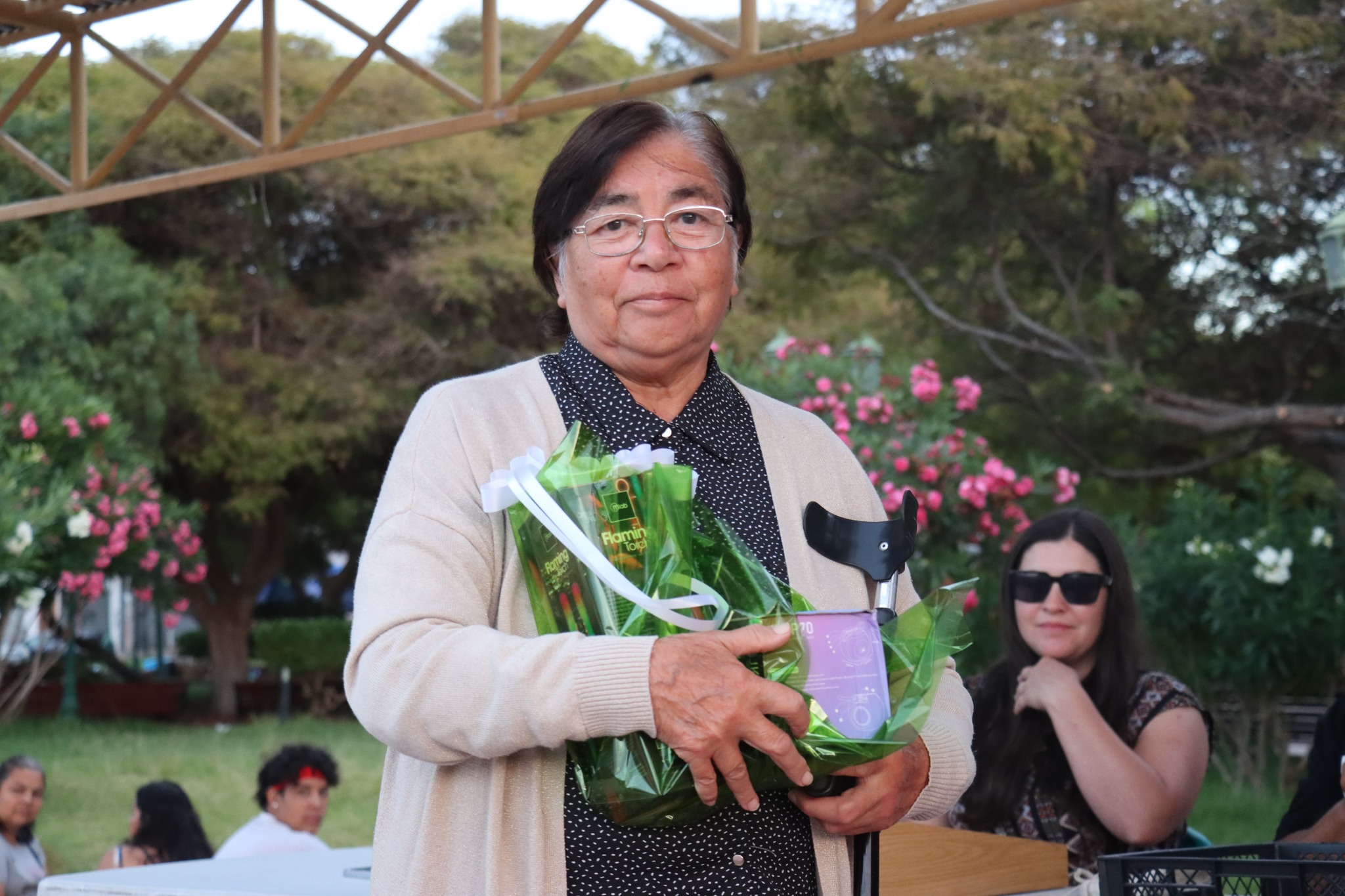 Participante muestra premios de artesanía (figura y accesorios) en el Gran Bingo Veraniego en Plaza de Armas, Taltal.