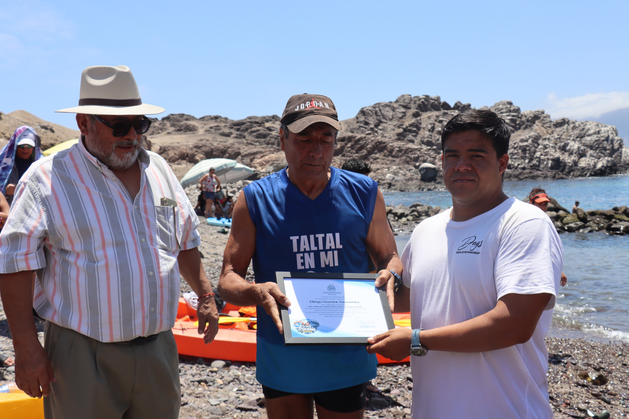 Tarzán Álvarez entrega diploma a Diego Gómez Saavedra por participación en travesía honor Virgen de Lourdes Taltal 2026.