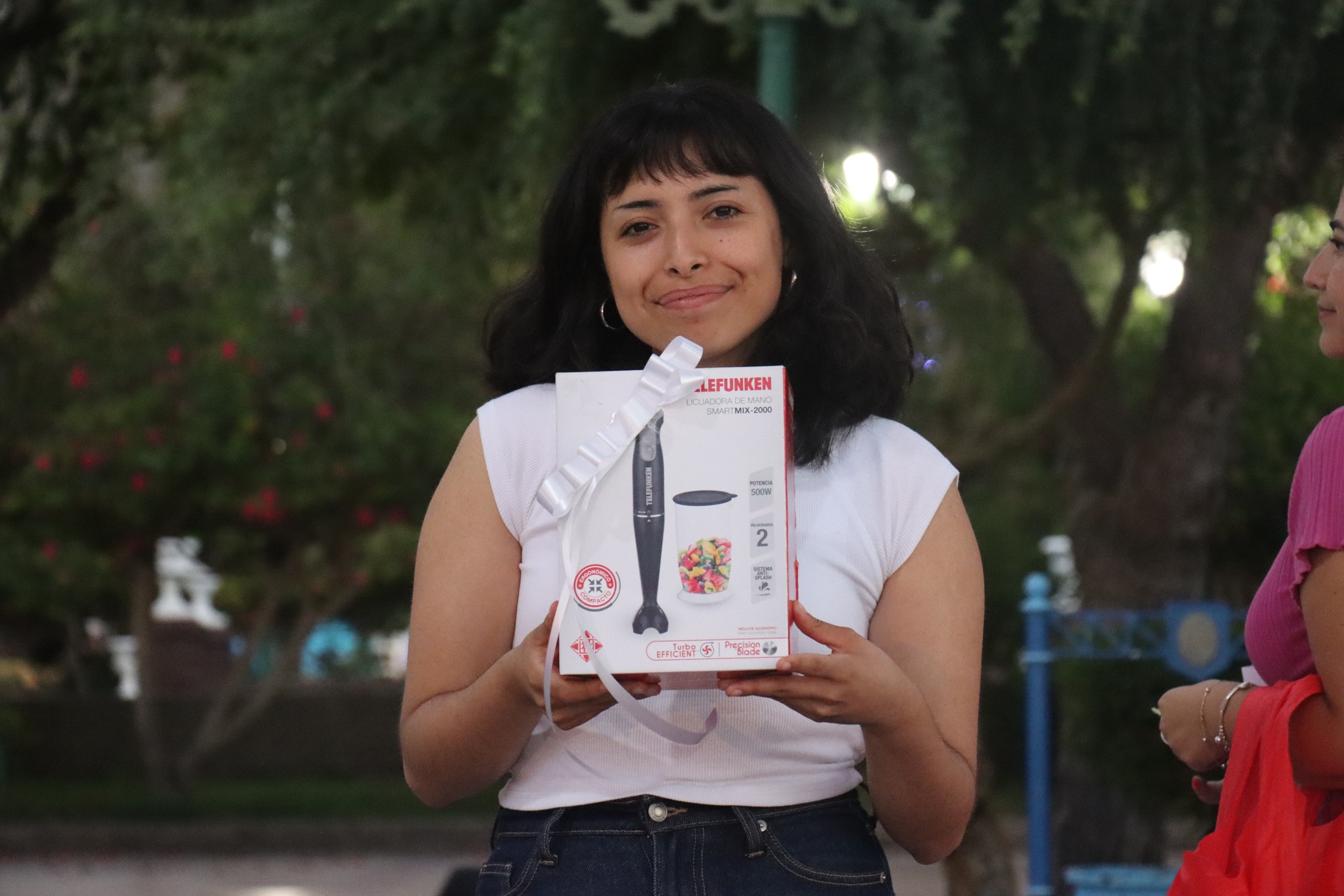 Ganadora muestra su premio, una licuadora de mano, en el Gran Bingo Veraniego de Plaza de Armas, Taltal.