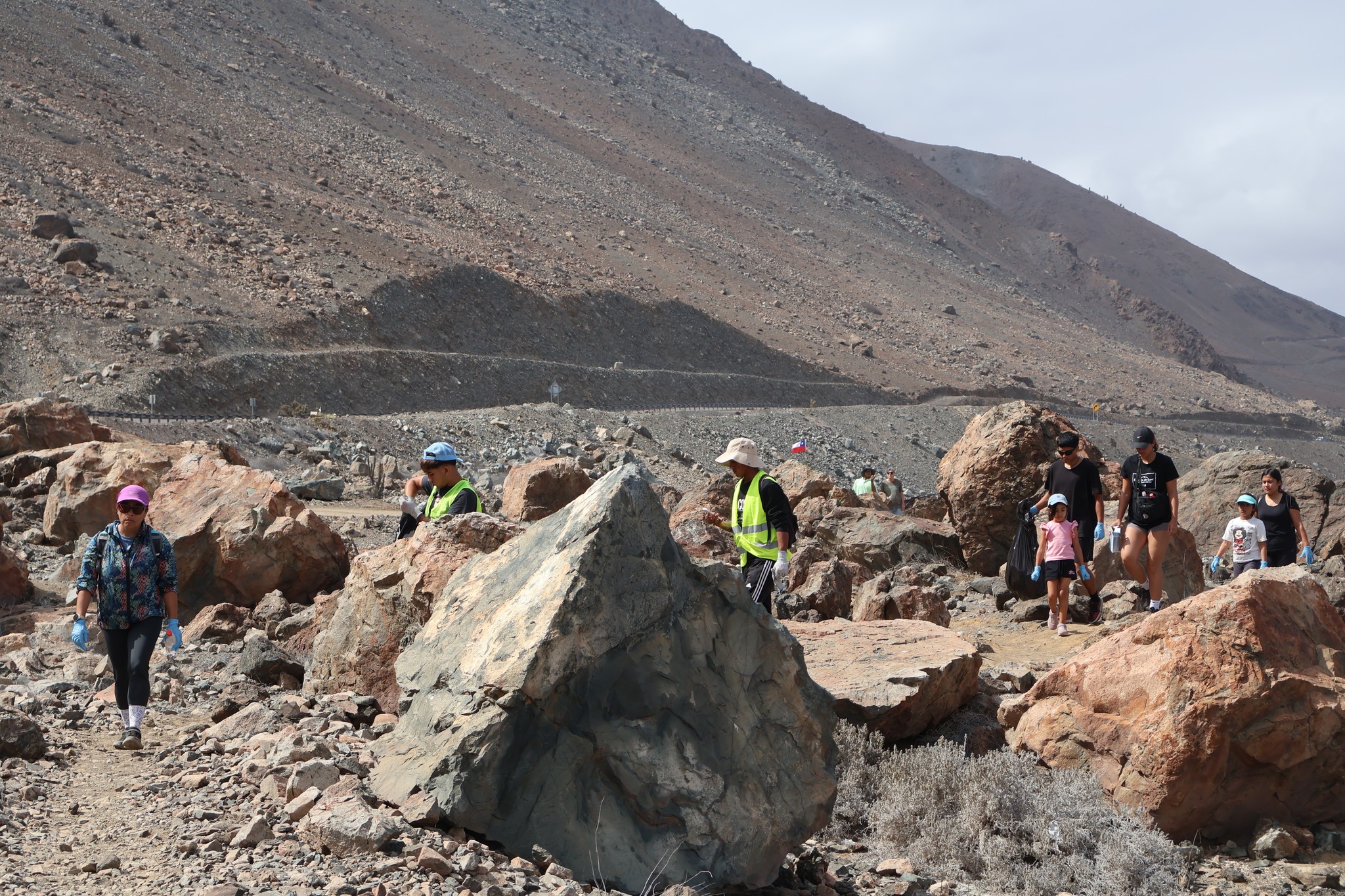 Participantes con bolsas negras retiran residuos del borde costero de Taltal durante jornada comunitaria.