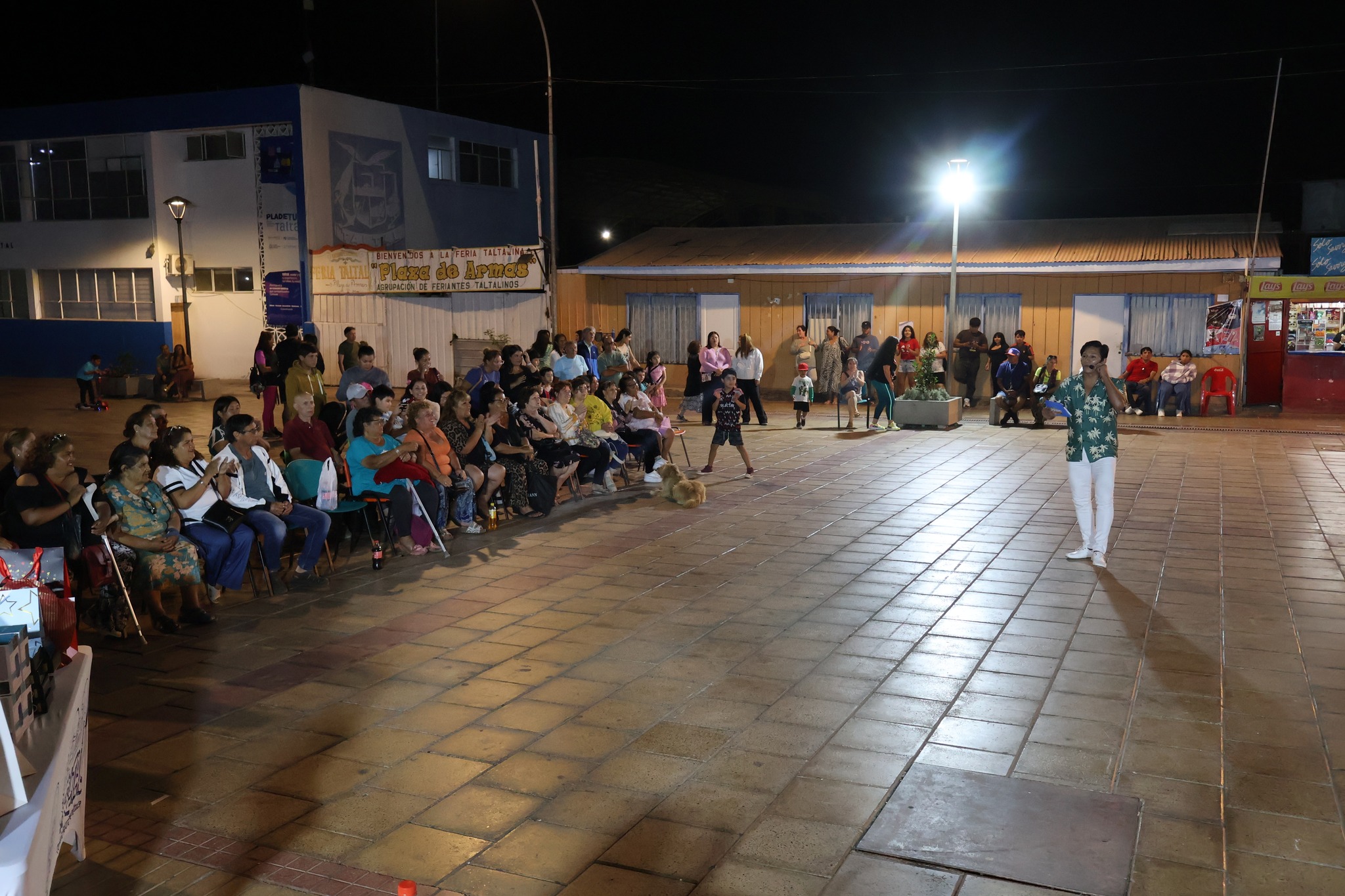 Panorámica nocturna de la Plaza de Armas de Taltal con público y pista central de baile.