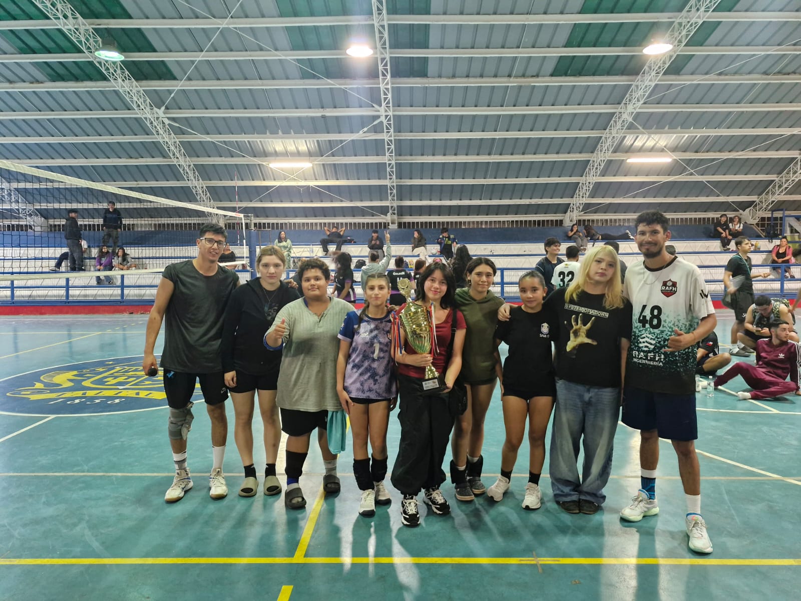 Equipo de Academia junto a su entrenador Sergio Santibáñez posa con la copa de subcampeonas en la ceremonia de premiación del Voleibol Verano Taltal 2026.