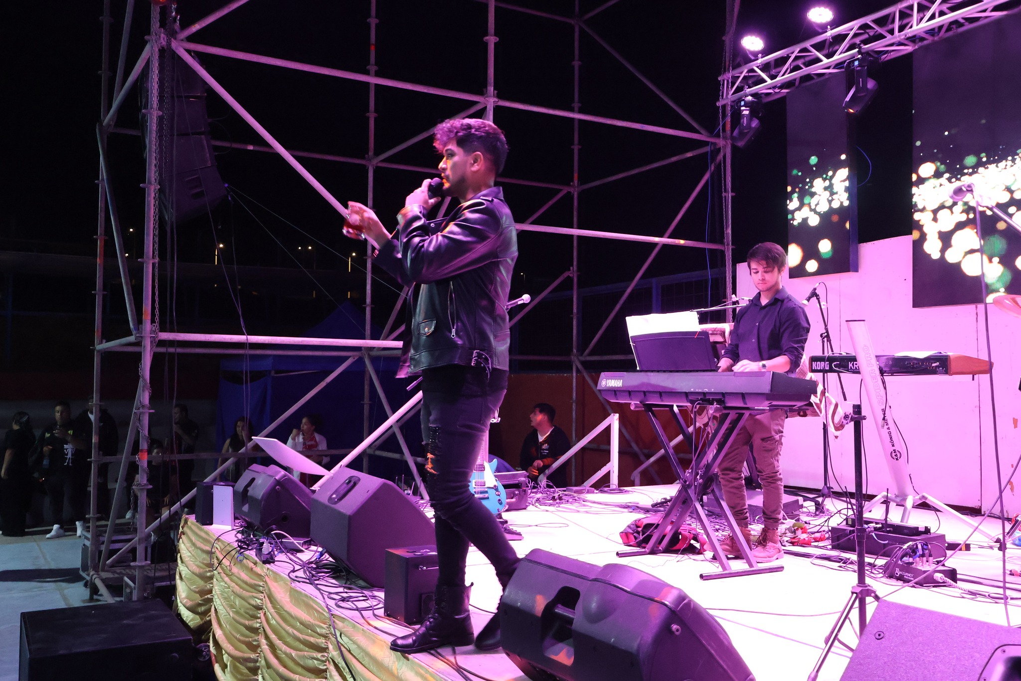 Doble oficial de Prince Royce cantando en el escenario junto a músico acompañante durante el cierre del Verano 2026 en Paposo.