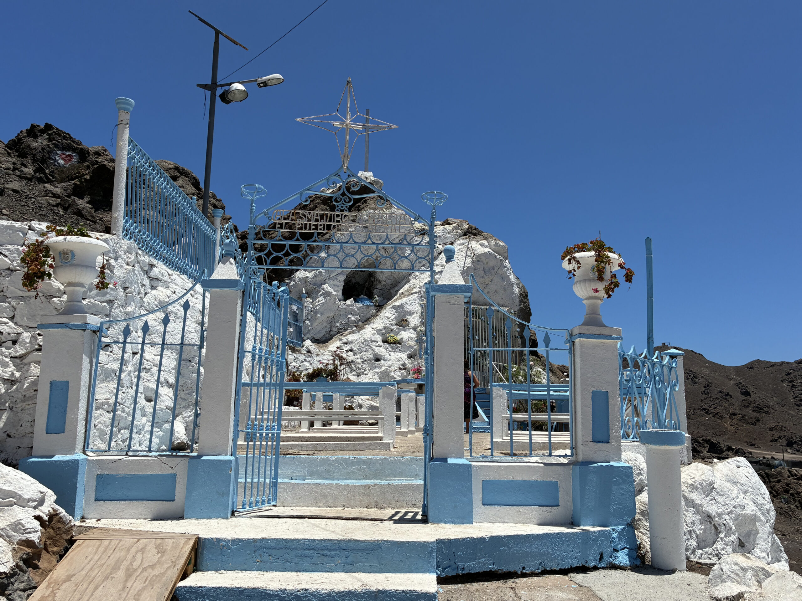 Gruta de Nuestra Señora de Lourdes en el sector La Puntilla, Taltal, con su entrada azul y blanca bajo un cielo despejado, durante los preparativos de la Fiesta 2026.
