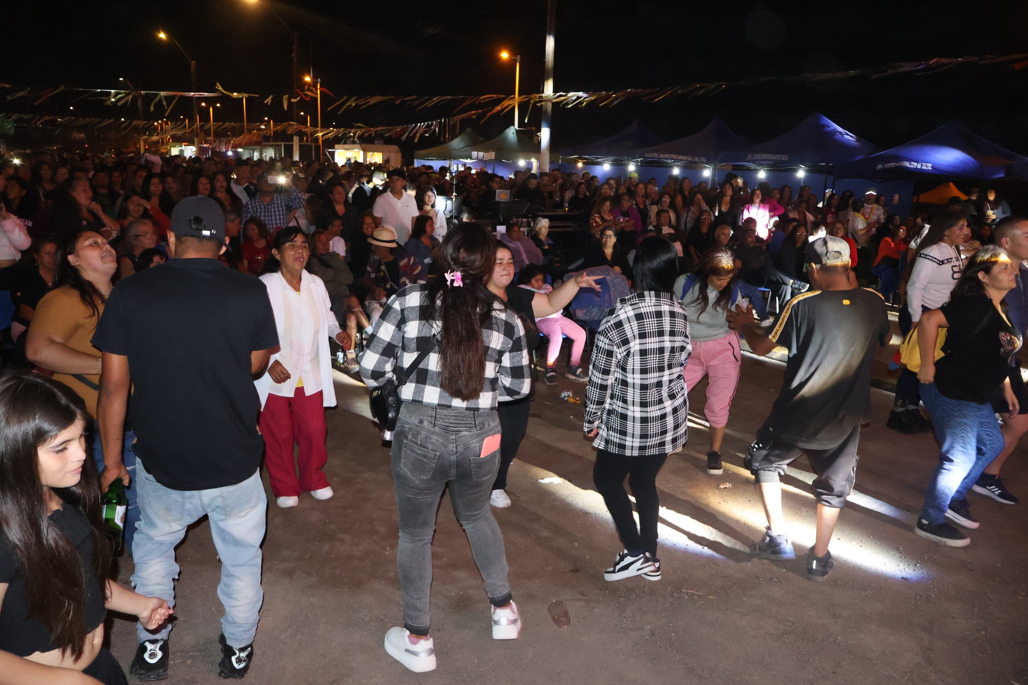 Vecinos y asistentes bailando durante el Gran Carnaval Bailable de Poza Las Peñas organizado por la Municipalidad de Taltal, cierre temporada estival 2026.