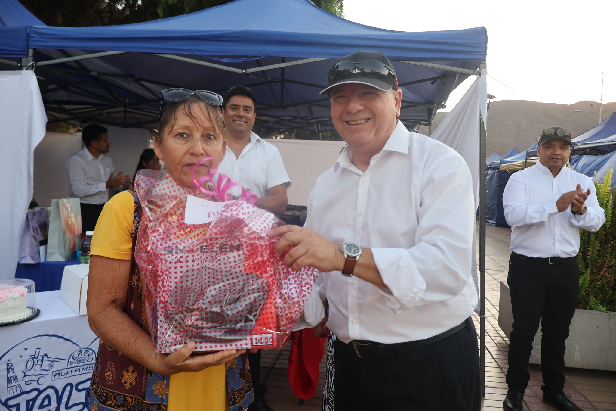 Premiación a vecina con set de regalo en actividad municipal por el Día de la Mujer en Taltal.