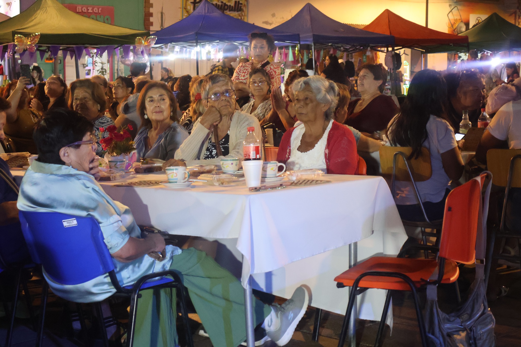 Mujeres sentadas en mesas durante onces Día Mujer Taltal