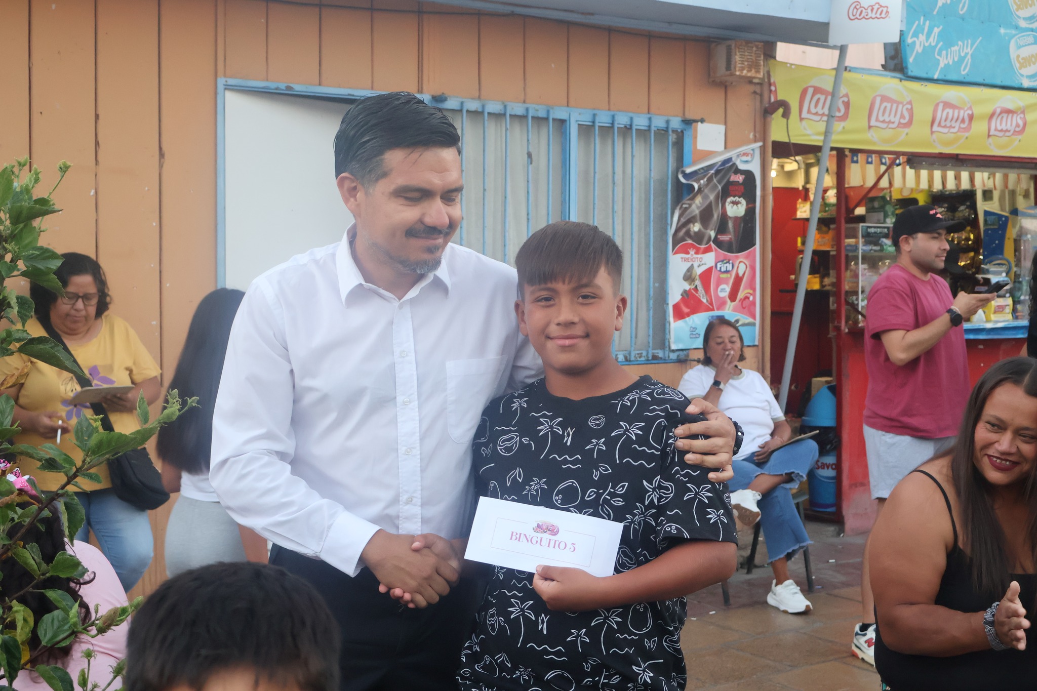 Funcionario entrega Binguito 5 a niño ganador evento Taltal