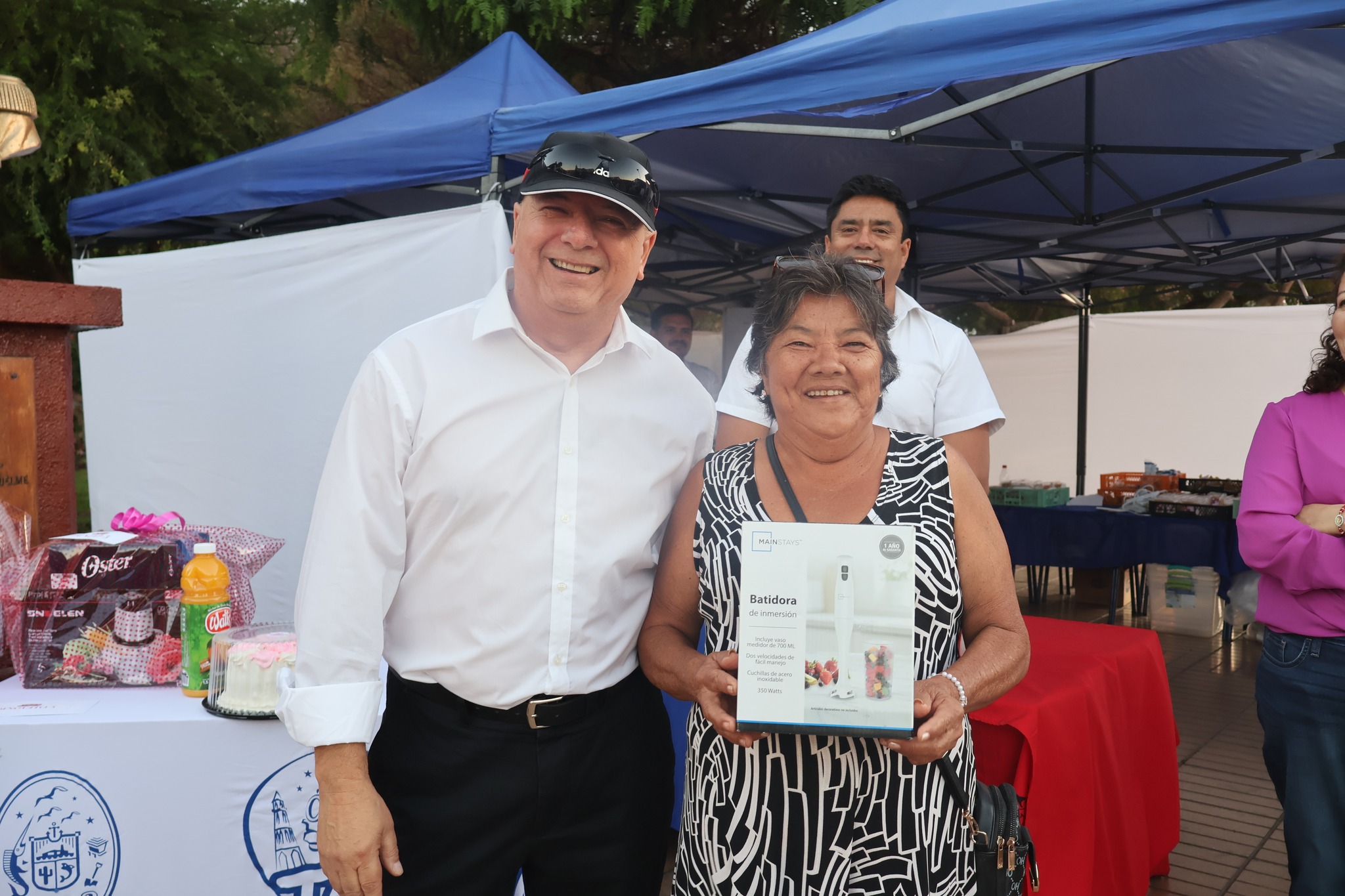 Ganadora posa con premio junto a autoridad en jornada del Día Internacional de la Mujer en Taltal.