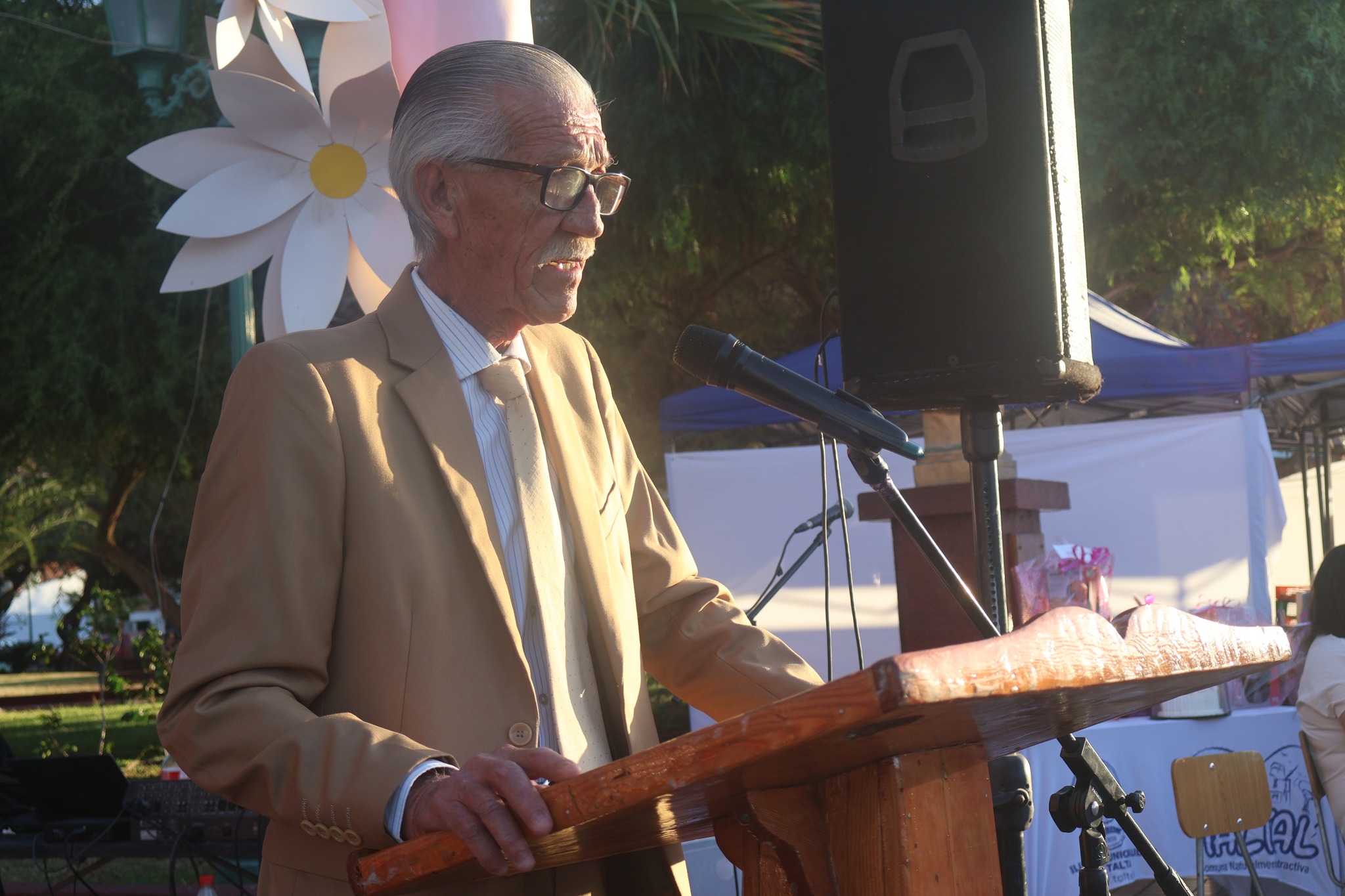 Alcalde Mario Acuña Villalobos en podio entrega mensaje en escenario del Día Internacional de la Mujer en Taltal.