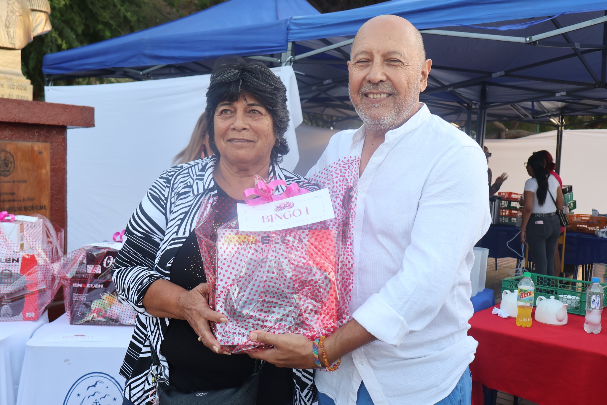 Ganadora recibe premio “Bingo 1” en actividad del Día Internacional de la Mujer en Plaza de Armas de Taltal.