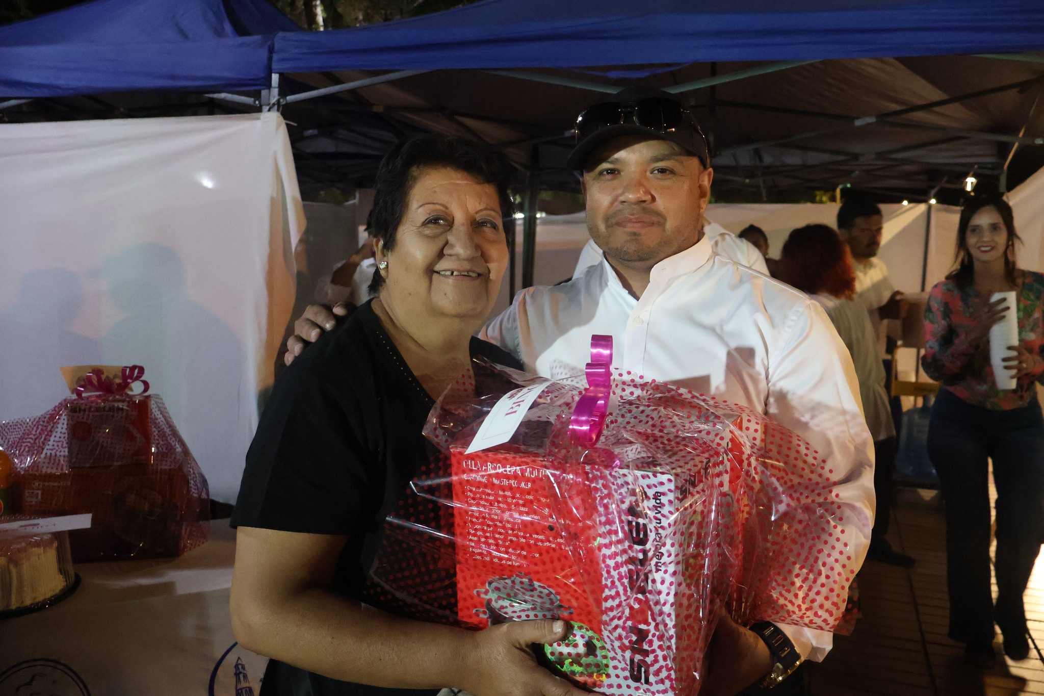 Funcionario municipal entrega canasta a ganadora evento Taltal