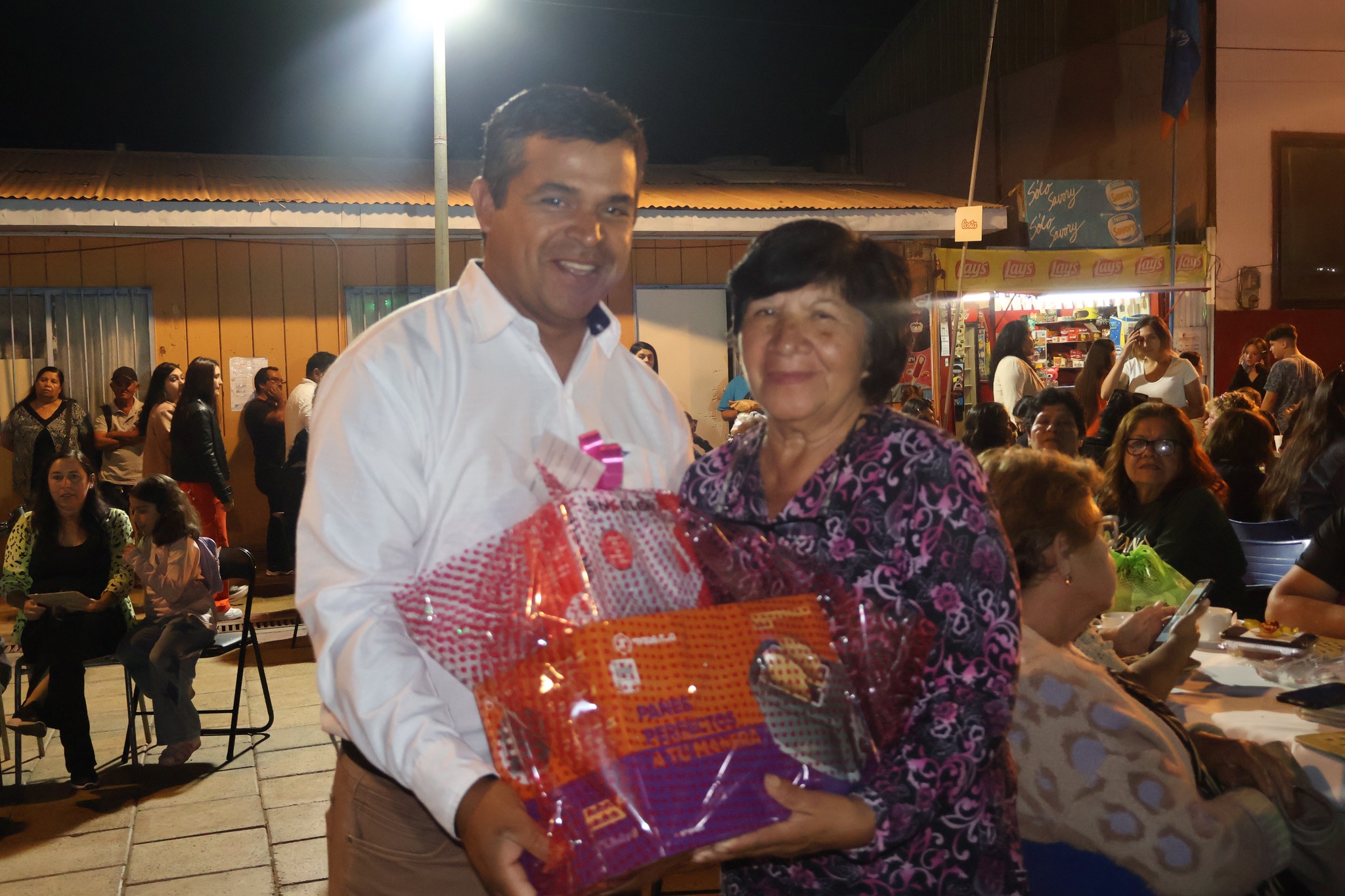 Concejal Segundo Llanos entrega canasta de regalo a asistente evento Taltal