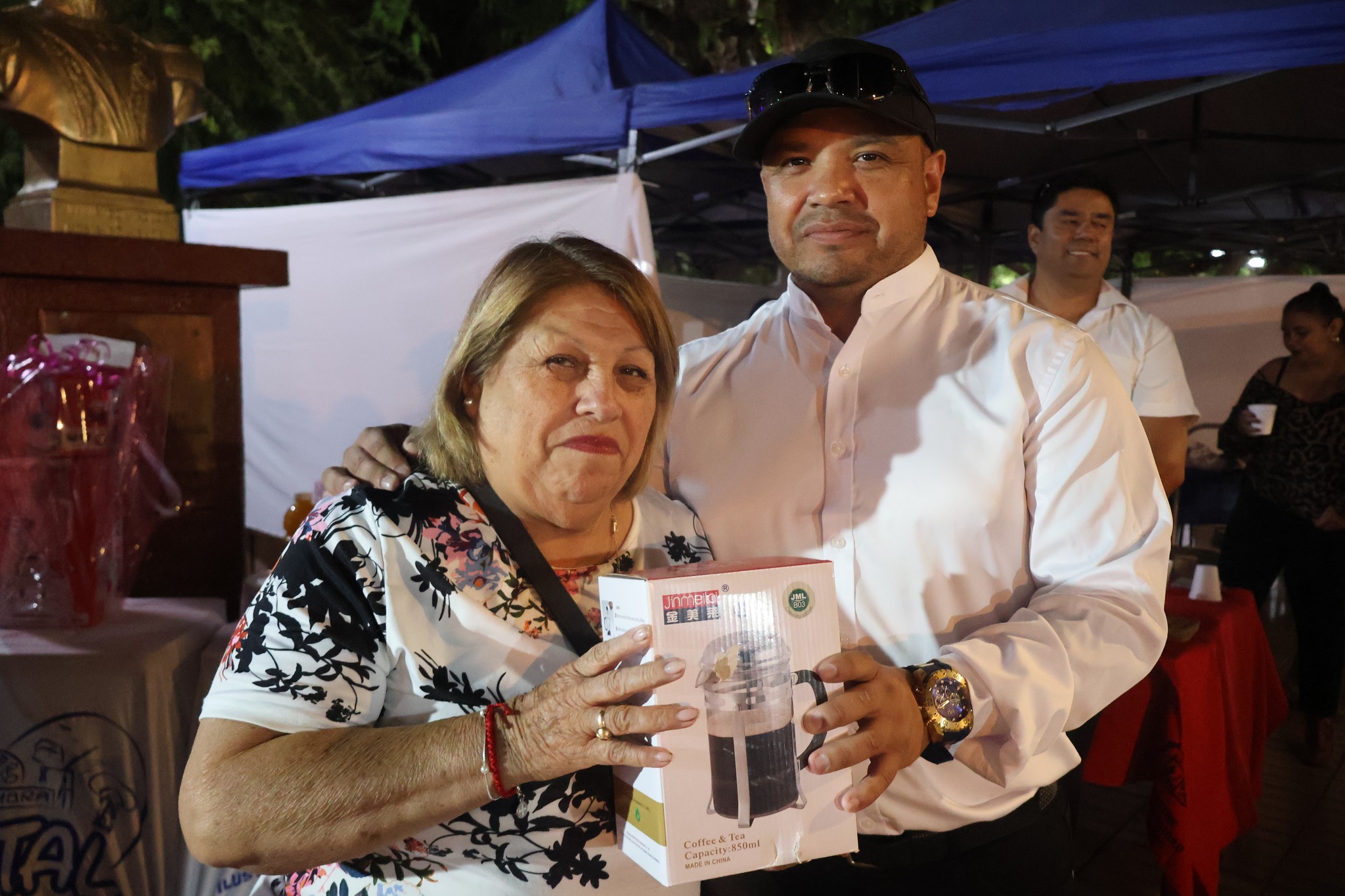 Funcionario entrega cafetera a ganadora bingo celebración Taltal