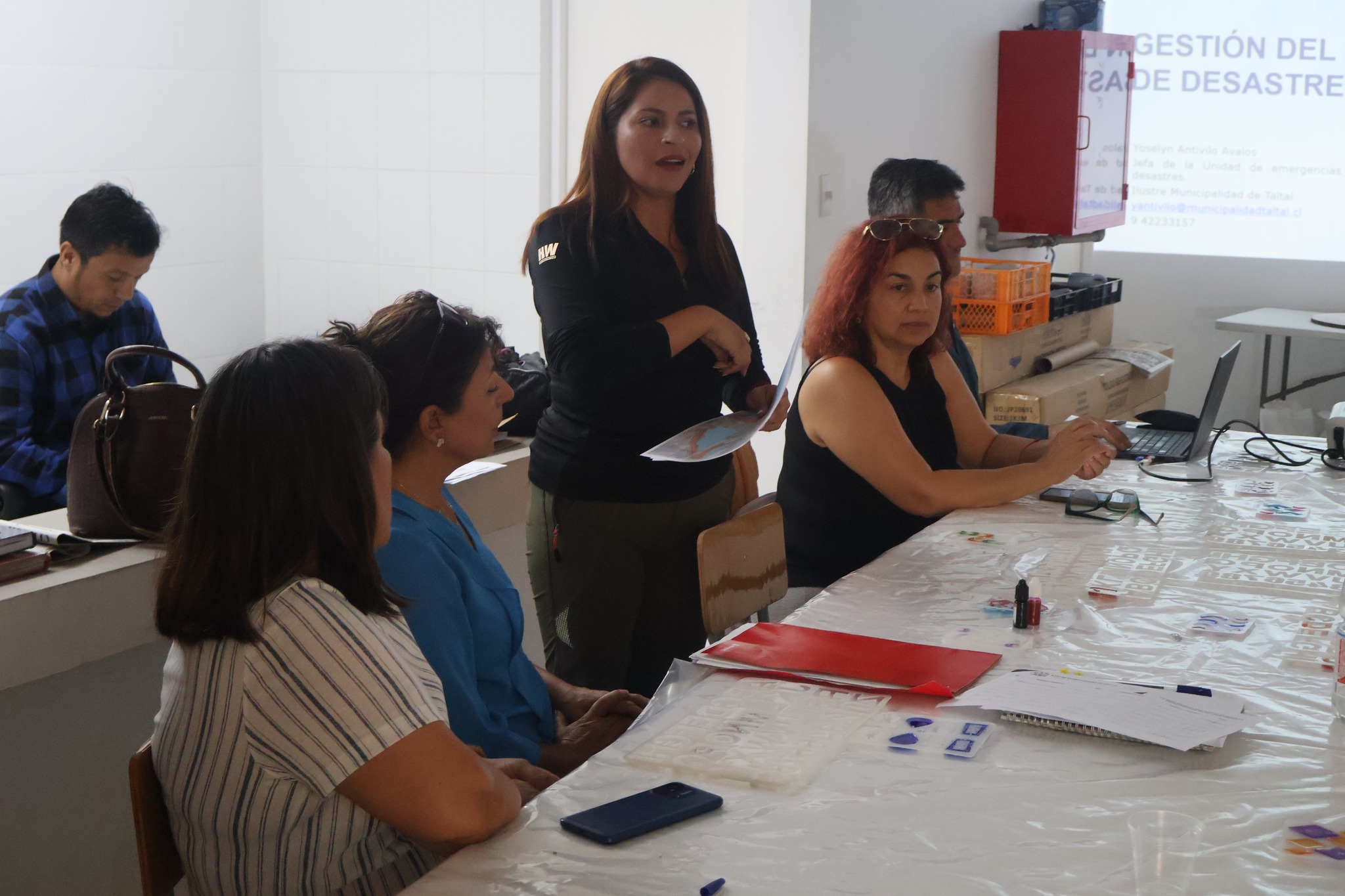 Funcionaria municipal expone durante reunión informativa con vecinos de la Junta de Vecinos N°12 San Lorenzo en Taltal.