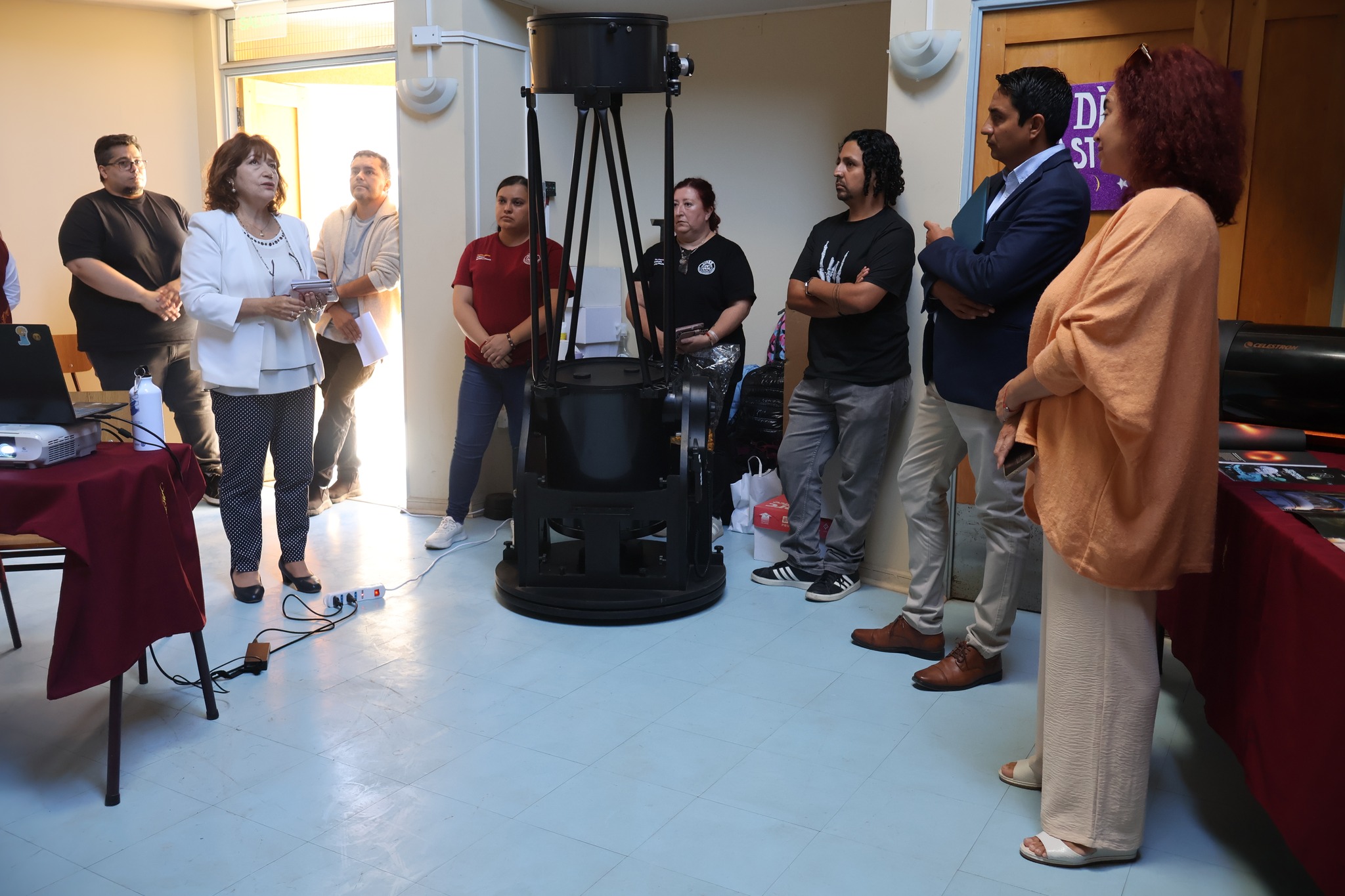Autoridades y asistentes observan equipamiento astronómico durante actividad de la Academia de Astronomía en el Liceo C-21 de Taltal.