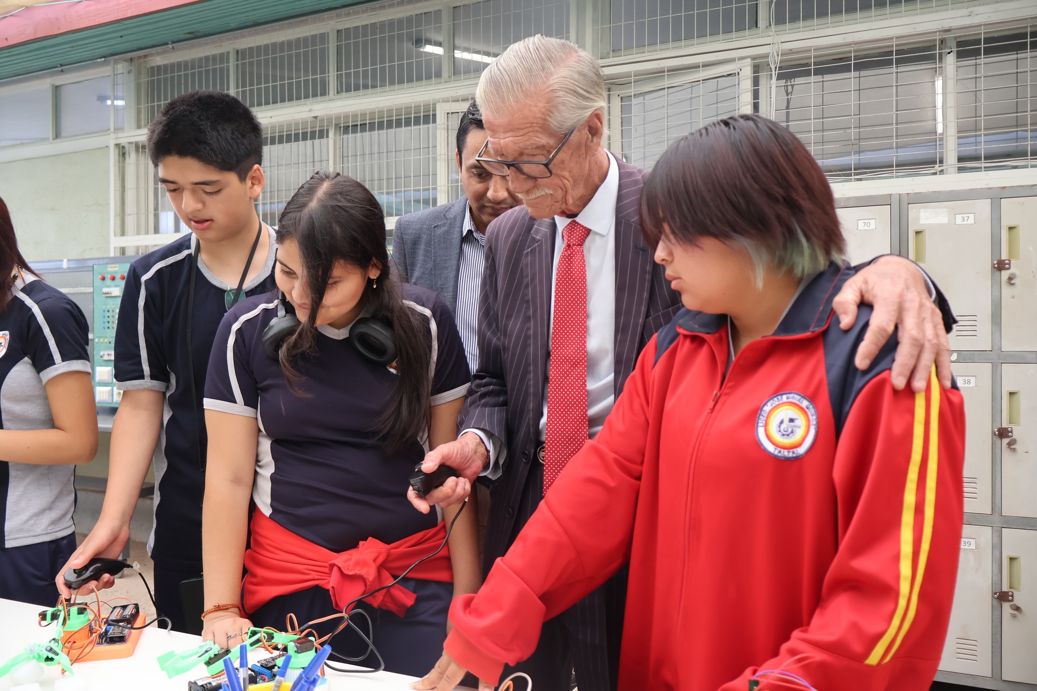 Autoridad comunal junto a estudiantes revisando proyectos de electrónica en laboratorio Impulsa 4.0 Taltal