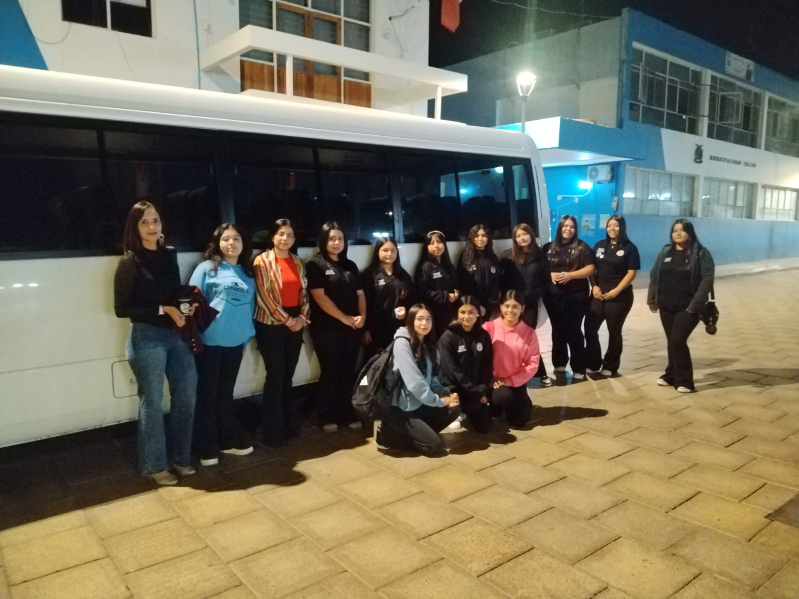 Estudiantes de la comunidad Somos Más Bakanas del Liceo Politécnico José Miguel Quiroz de Taltal posan junto a un minibús antes de participar en el seminario Mujer, Conectividad y Minería en Antofagasta.
