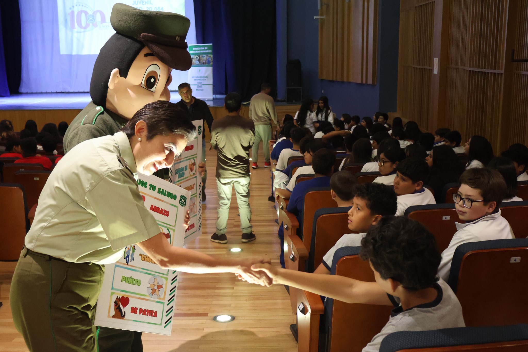 Funcionaria de Carabineros interactúa con estudiantes en actividad educativa sobre convivencia y responsabilidad.