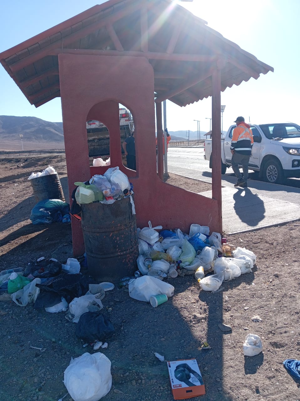 Operativo de limpieza en el acceso a Taltal, en el cruce de la Ruta 1 con la Ruta 5, con basura acumulada junto a contenedores.
