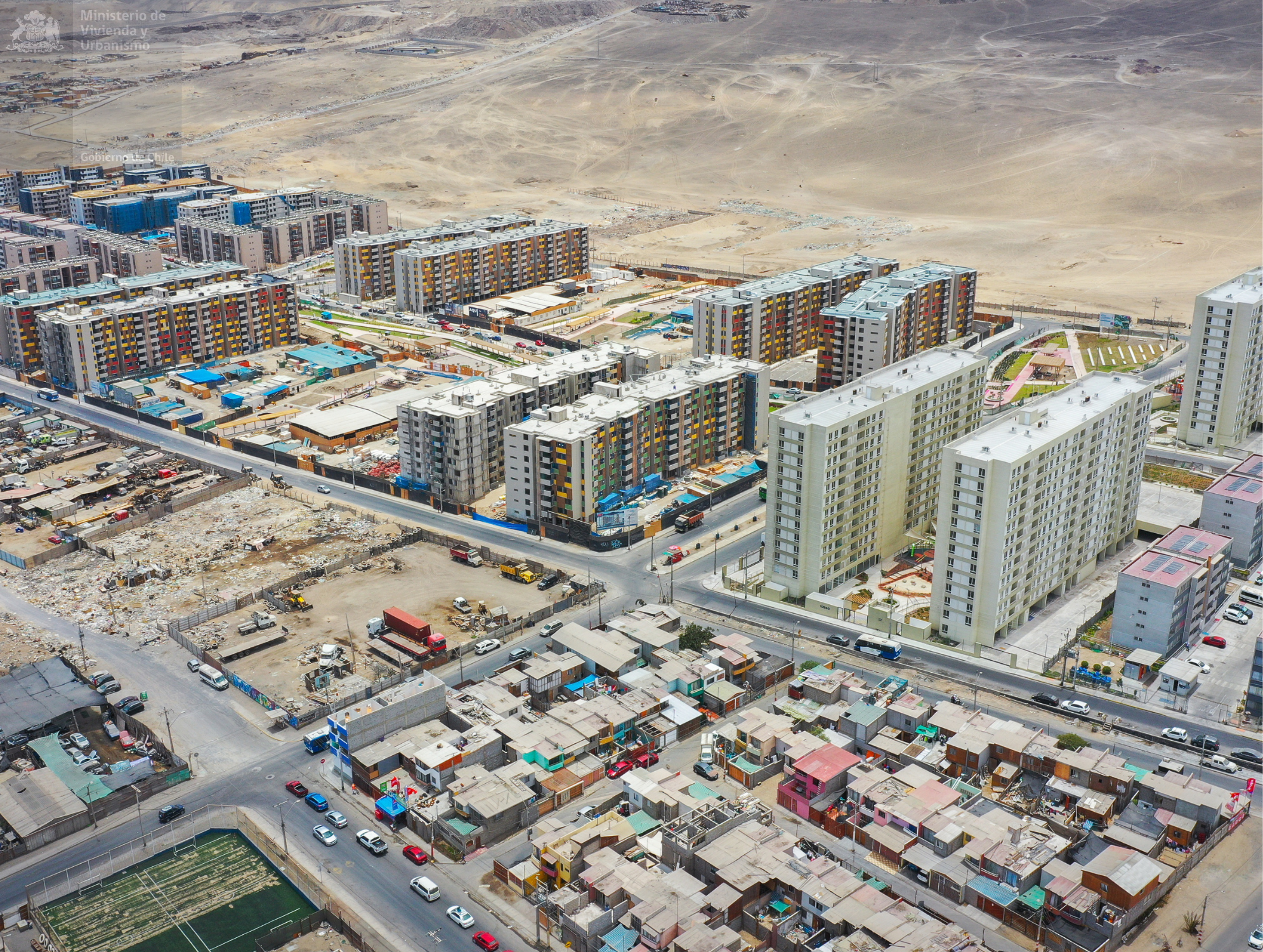 Vista aérea de conjuntos habitacionales, viviendas y terrenos desérticos en un sector urbano de Antofagasta.